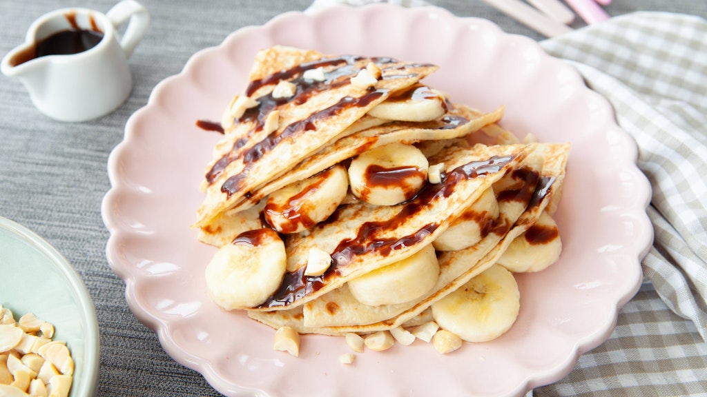 Mit Bananen und ein bisschen Schokosoße schmecken Eierkuchen kleinen Süßmäulern besonders gut.