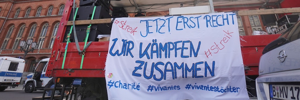 Ein Transparent mit der Aufschrift „Jetzt erst recht - wir kämpfen zusammen“ ist vor dem Roten Rathaus zu sehen.