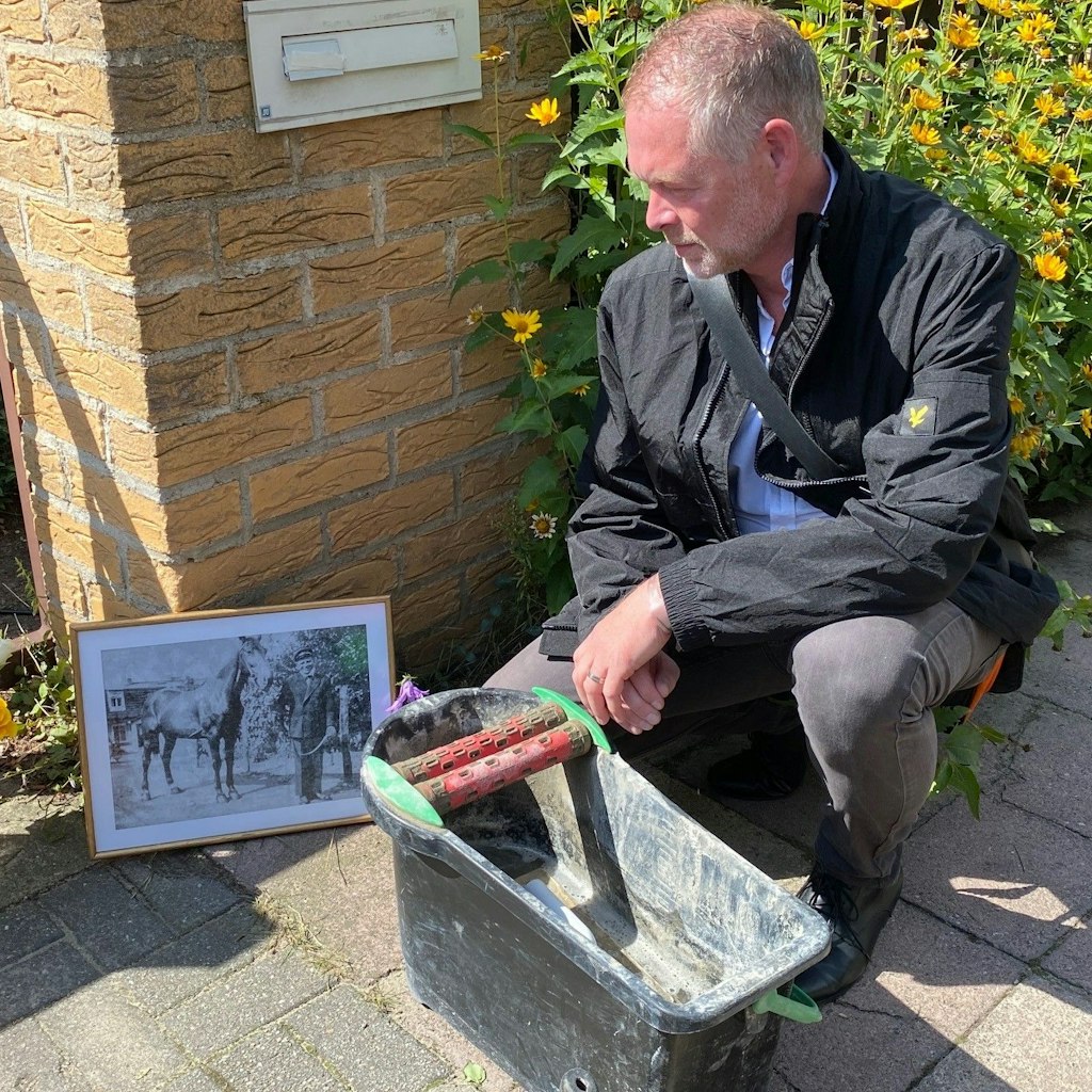 Der Großneffe, Sven Bauschus, vor dem Foto von Bruno Lüdke. Dort wurde der Stein verlegt.