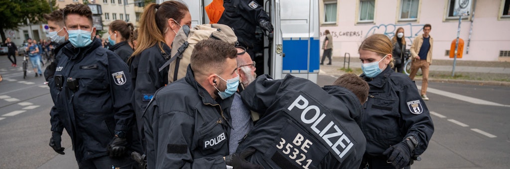 Berlin: Polizisten halten einen Teilnehmer der Demonstration fest.