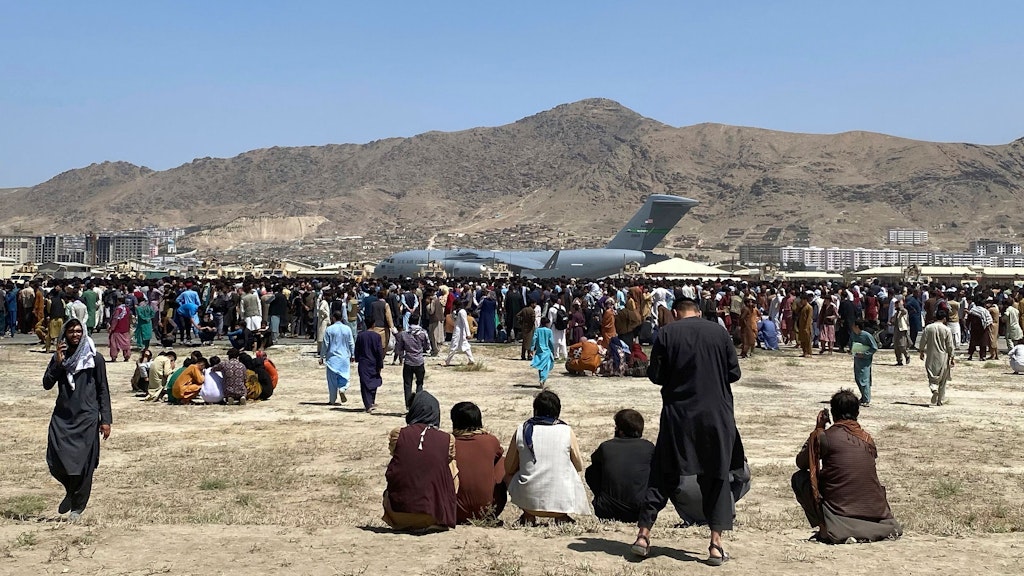 Hunderte von Menschen versammeln sich in der Nähe eines Transportflugzeugs der US-Luftwaffe von Typ C-17 auf dem Gelände des internationalen Flughafens in Kabul.