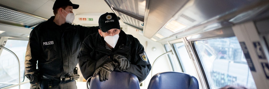 Beamte der Bundespolizei sprechen im Regionalzug vom Berliner Hauptbahnhof zum Flughafen BER mit einem Fahrgast