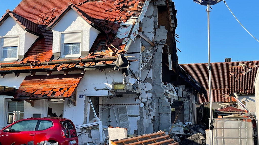 Nach der Explosion eines Wohnhauses ist das Nachbarhaus von Beschädigungen schwer gezeichnet. 