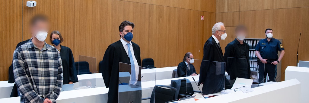 Die zwei wegen Mordes angeklagten Männer (l und 2.v.r.) stehen vor Beginn der Verhandlung mit ihren Anwälten Sarah Stolle und Alexander Betz (3.v.l.), Patrick Ottmann (4.v.r.) und Gerhard Bink (3.v.r.) im Sitzungssaal.