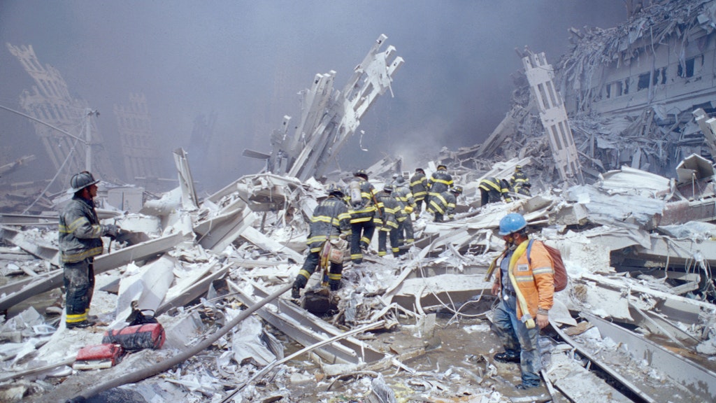 Feuerwehrleute klettern über die Trümmer des zweiten Turms des World Trade Centers.