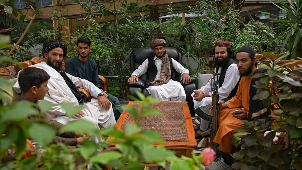 Taliban-Kämpfer in Dostums Gewächshaus – die Kalaschnikow ist ständig dabei.