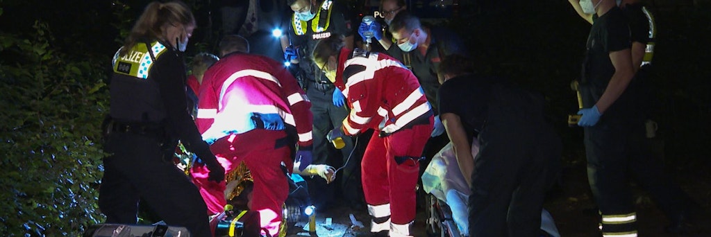 Hamburg: Sanitäter und Polizisten bemühen sich in der Nacht um eine verletzte Person.