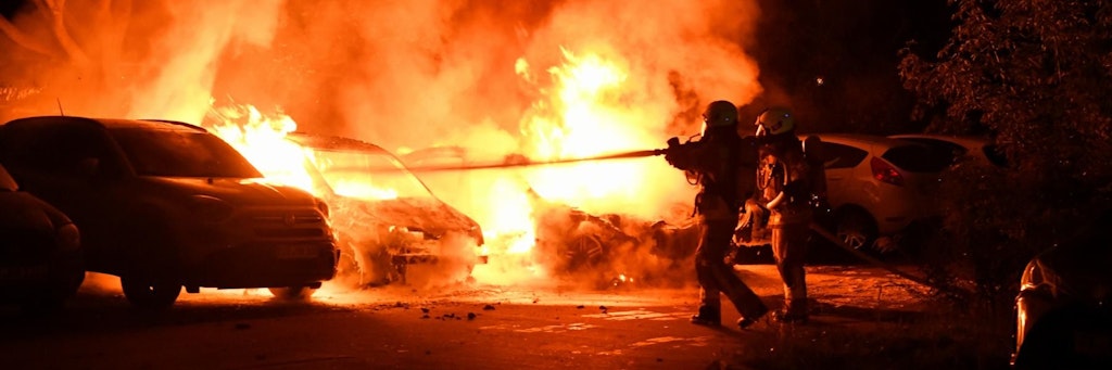 Feuerwehrleute löschen die Flammen in den brennenden Autos.