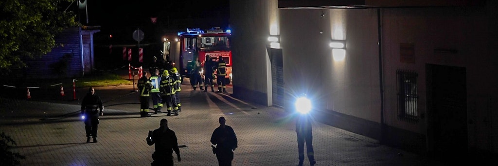 Mit Taschenlampen suchen Polizeibeamte das Areal um das Impfzentrum in Eich nach Spuren ab.