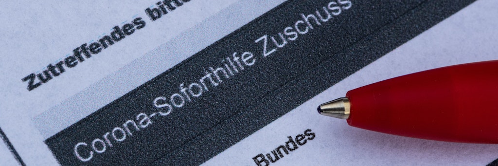 Ein Stift liegt auf einem Antrag für den Corona-Soforthilfe-Zuschuss. 
