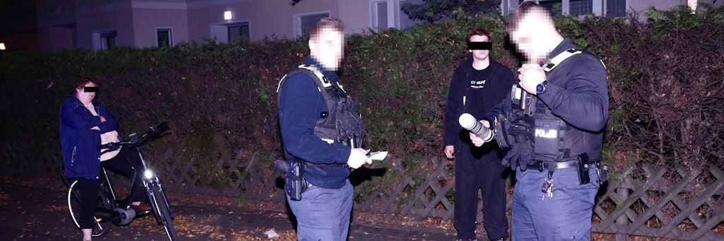 Polizisten halten die Mutter in ihren Sohn in Schach.