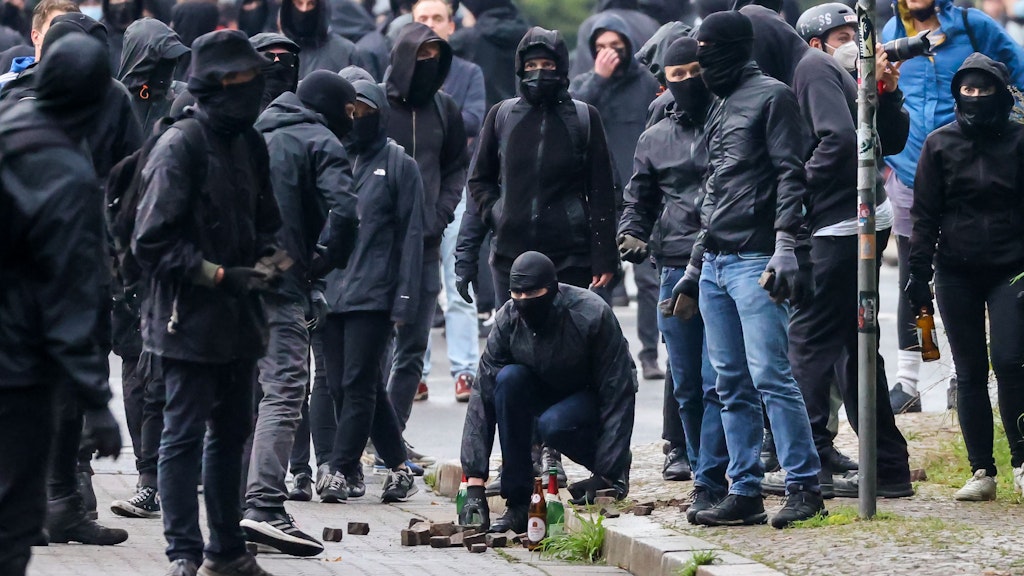 Leipzig: Linke Demonstranten sammeln Steine.