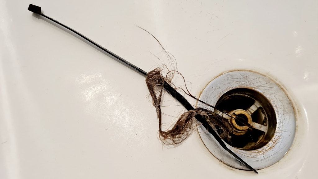 Einen verstopften Abfluss kann man zum Beispiel mit Kabelbinder reinigen und so die Haare herausbekommen.