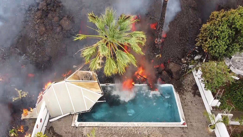 Eine Villa mit Pool wird von der Lava überrollt. 