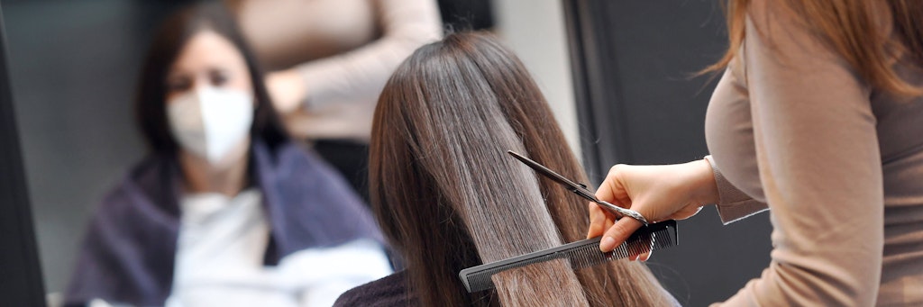 Eine Frau im Friseursalon (Symbolbild). In Indien hat ein Friseur seine Kundin missverstanden und schnitt die Haare zehn Zentimeter kurz statt nur die Spitzen.