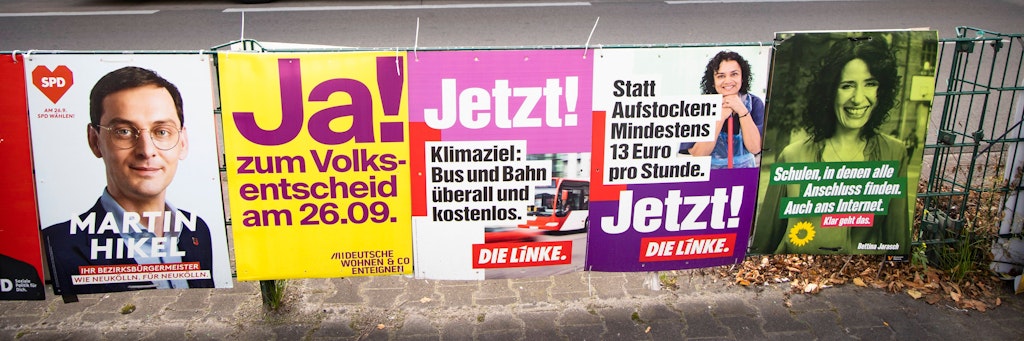 Verschiedene Wahlplakate vor einer Bushaltestelle in Berlin Neukölln.