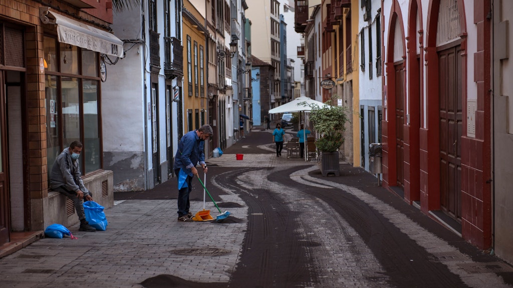 Einwohner reinigen die Straßen von Santa Cruz de la Palma von Ascheresten.