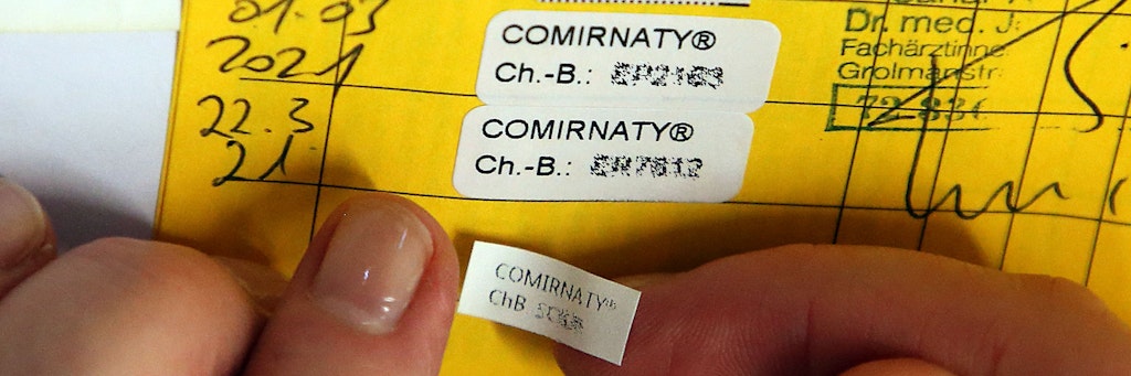 Berlin: Eine Ärztin klebt den Nachweis für die dritte Impfung mit dem Comirnaty-Impfstoff des Herstellers Biontech/Pfizer in ein Impfbuch. Um einen möglichst hohen Schutz gegen das Coronavirus zu erhalten, werden verstärkt in den Arztpraxen die Angebote für die Drittimpfung ausgesprochen.