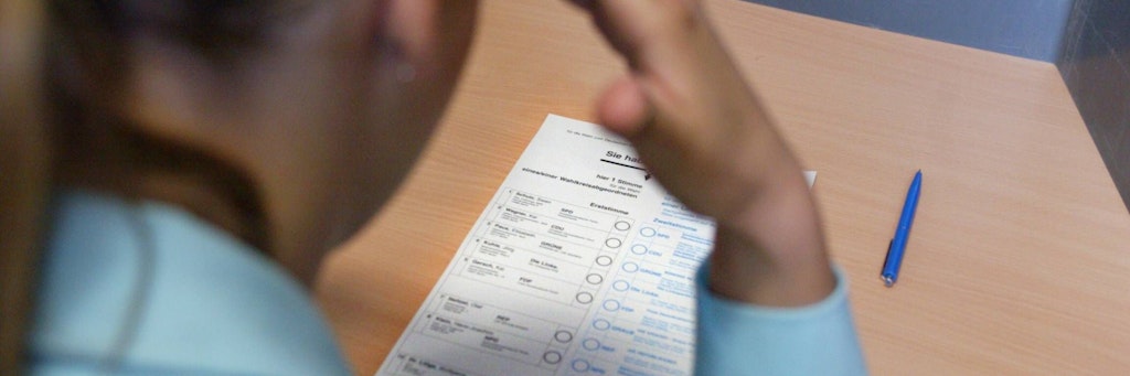 Eine junge Wählerin in der Wahlkabine