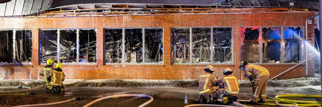 Einsatzkräfte der Berliner Feuerwehr kämpfen in der Silvesternacht gegen die Flammen in einem Supermarkt in Neukölln.