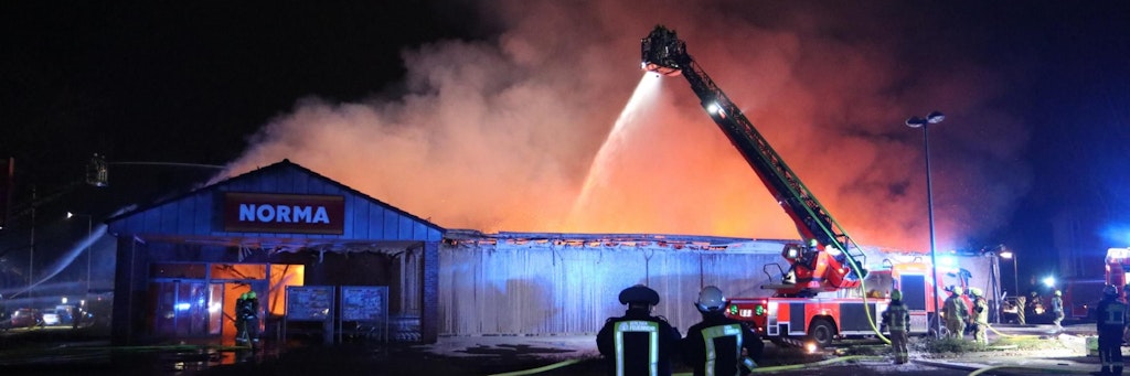 Der Supermarkt steht in Flammen, die Feuerwehr versucht zu retten, was zu retten ist.