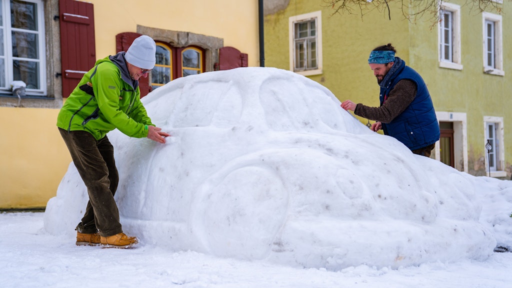  Eberhard Burger (l.) und Stefan Parnt (r) modellieren an ihrem VW-Käfer aus Schnee. 