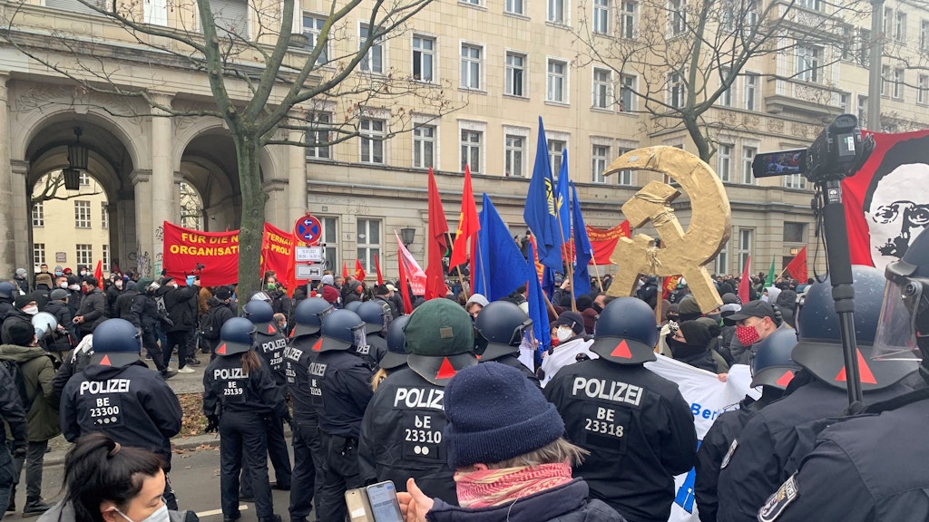 Die Polizei versucht, der Handvoll von blauen FDJ-Fahnen habhaft zu werden. Demonstranten schirmten die Fahnenträger ab. 