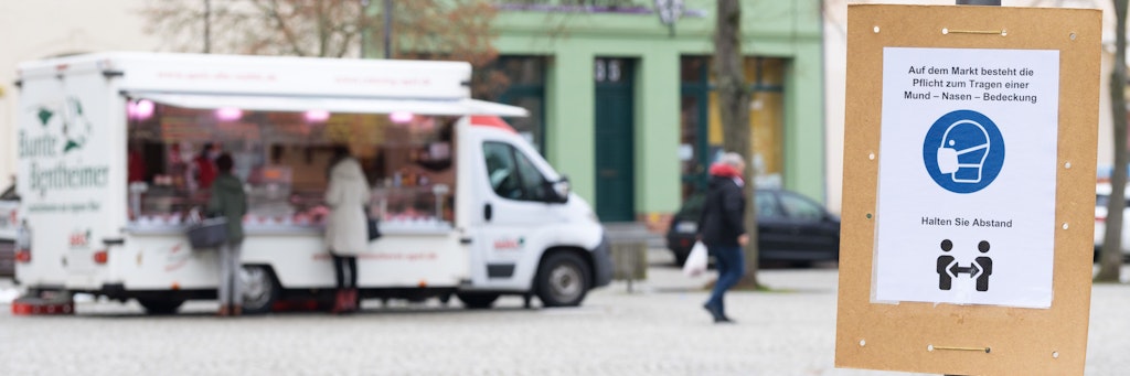 Ein Schild fordert die Besucher des Marktplatzes in der Innenstadt zum Einhalten des Abstandes auf. 