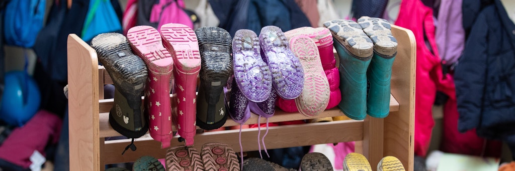 Kinderbekleidung und Stiefel sind in einer Kindertagesstätte zu sehen. 