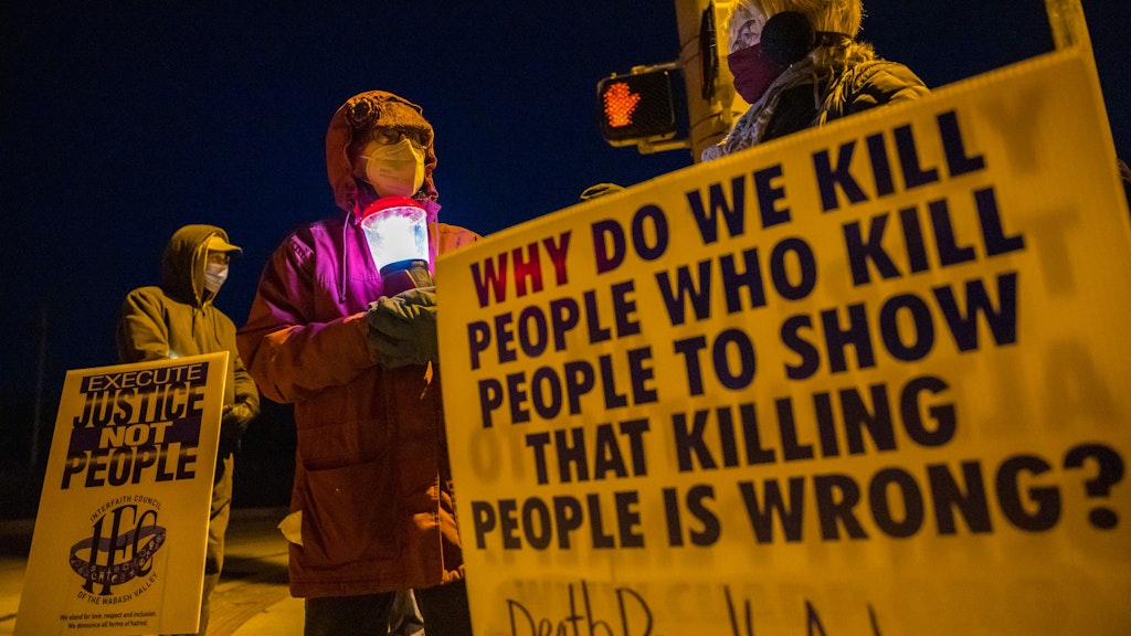 Glenda Breeden (M.) aus Bloomington, Aktivistin gegen die Todesstrafe, hält eine Lampe bei einem Protest gegen die Hinrichtung von Lisa Montgomery und zwei weiteren Personen im Gefängnis in Terre Haute.