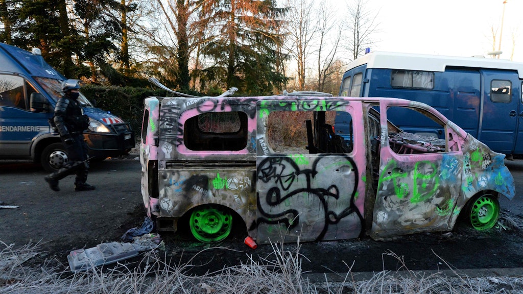 Ein Polizei-Van wurde abgefackelt und anschließend angesprüht.
