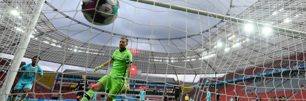 Wolfsburgs Ridle Baku (l.) trifft zum 1:0 und Bayers Keeper Lukas Hradecky kann dem Ball nur hinterherschauen. 