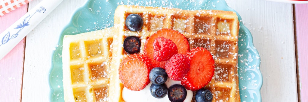 Knusprige Waffeln mit frischen Früchten und Puderzucker.