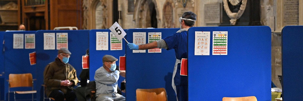 „Next, please!“ Ein Impfhelfer winkt in der Kathedrale von Salisbury mit der Wartenummer 5.