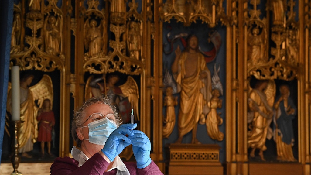 Eine Helferin prüft, ob die Spritze mit dem Biontech/Pfizer-Impfstoff richtig aufgezogen ist. Vielleicht hilft auch Erzengel Michael, in dessen Kapelle in der Kathedrale von Salisbury geimpft wird. 