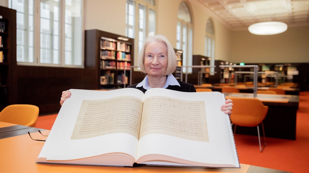 Barbara Schneider-Kempf hält im Musiklesesaal der Staatsbibliothek Unter den Linden ein Buch mit dem Faksimile der original Partitur der 9. Sinfonie von Ludwig van Beethoven.