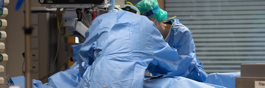 Auf einer Intensivstation bereitet Krankenhauspersonal einen Patienten auf künstliche Beatmung vor.