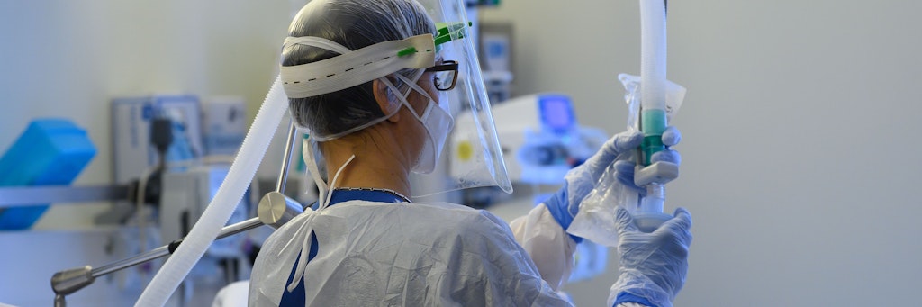 Eine Intensivpflegerin im Schutzanzug richtet auf der Covid-19 Intensivstation in der VAMED Klinik Schloss Pulsnitz einen Beatmungsschlauch ein.