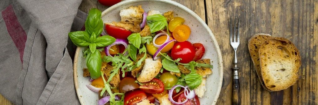 Ruckzuck ist aus altem Brot ein Brotsalat gemacht. In Italien wird er Panzanella genannt und ist meist aus geröstetem Ciabatta, roten Zwiebeln, Tomaten und Basilikum.