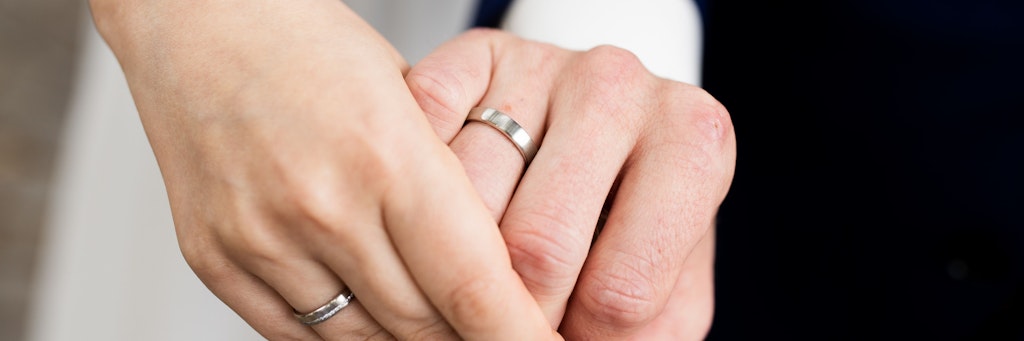 Ein frisch vermähltes Brautpaar zeigt nach der Eheschließung die Eheringe. Feiern ist in Corona-Zeiten zwar schwieriger, geheiratet wird deshalb aber nicht weniger.