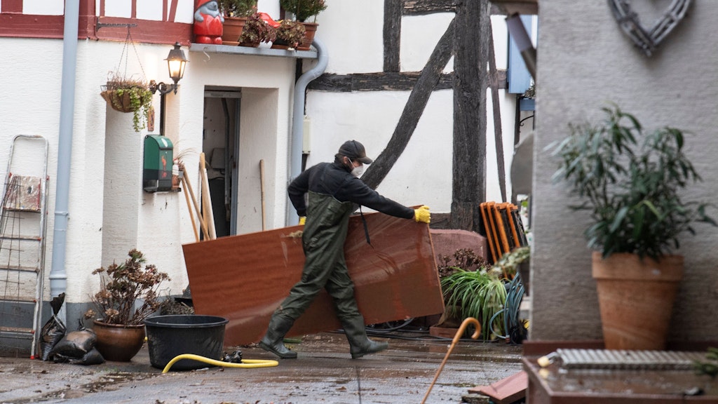 Menschen in Büdingen tragen nach dem Hochwasser zerstörte Möbel aus ihren Häusern.