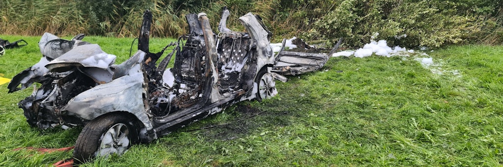 Das ausgebrannte Wrack des Autos am Fahrbahnrand in Brunsbüttel. 
