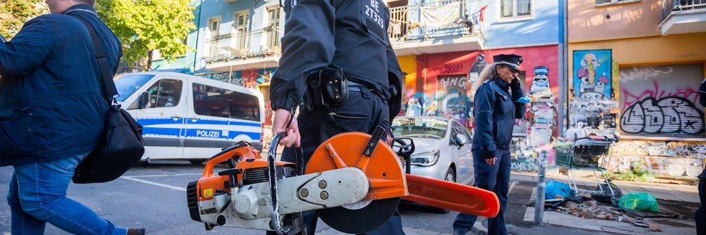 Ein Polizist trägt bei dem Polizeieinsatz im linken Hausprojekt in der Rigaerstraße 94 im Berliner Bezirk Friedrichshain schweres Gerät in das Haus. 