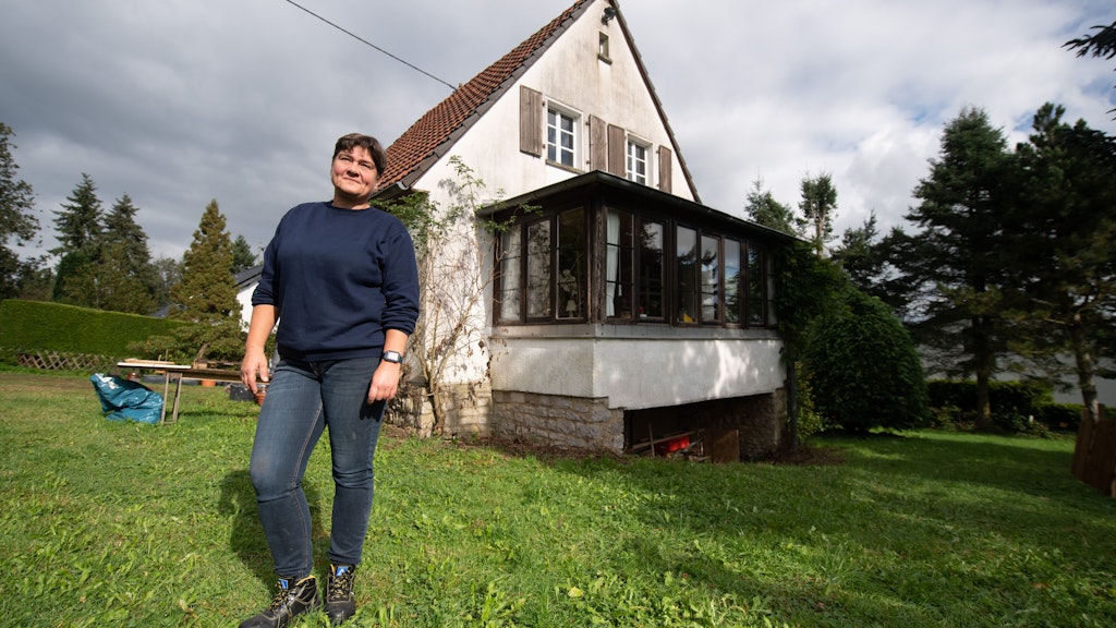 Manuela Göken steht vor ihrem neuen Haus in Hümmes am Rande des Ahrtals. Bis vor wenigen Wochen hatte sie gemeinsam mit ihrem Partner in einem Haus in Insul in unmittelbarer Nähe zur Ahr gewohnt.