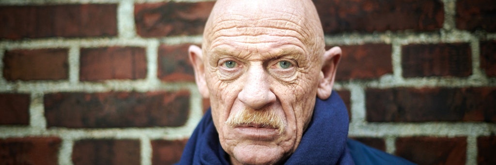 Der Gefängnisarzt und Schauspieler Joe Bausch, aufgenommen vor einer Mauer seiner Arbeitsstätte, der JVA Werl.