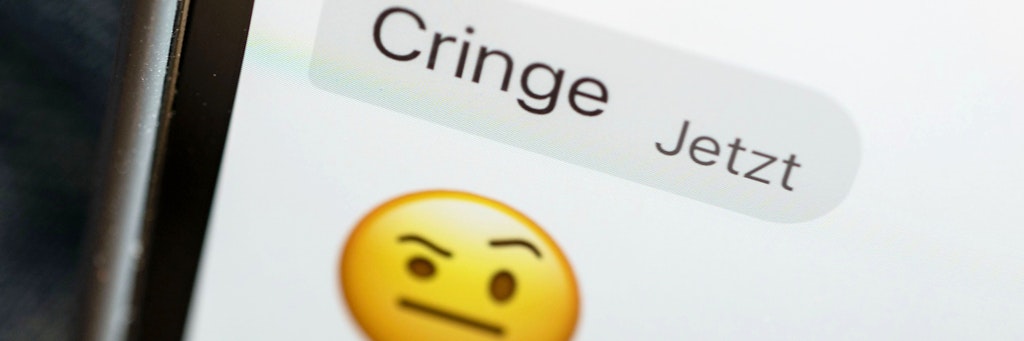 Das Wort „cringe“ ist auf dem Display eines Mobiltelefons zu sehen.