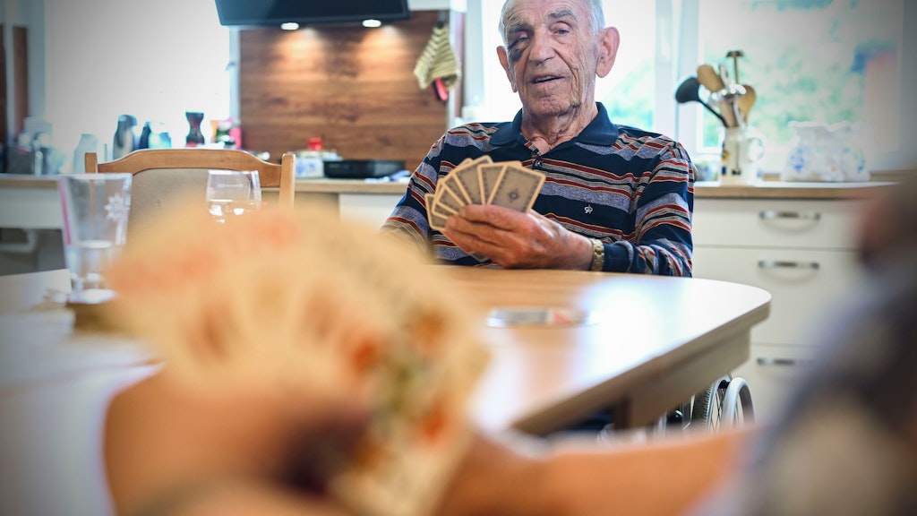 Edmund Neumann beim Kartenspiel im gemeinschaftlichen Wohnzimmer<br><br>