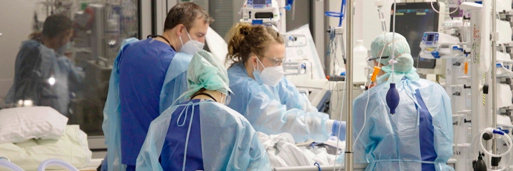 Ärzte und Pfleger arbeiten auf der Corona-Intensivstation der Charité am Bett einer jungen Patientin.