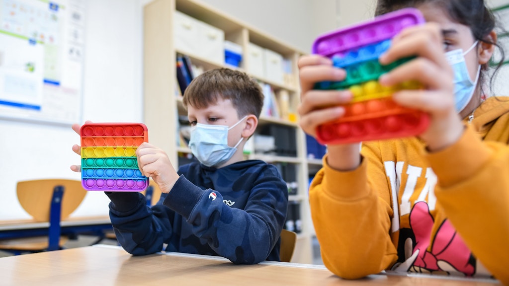 In einem Klassenzimmer einer Grundschule spielen Kinder mit Pop-Its.
