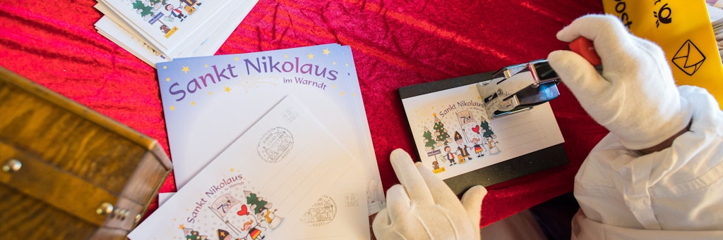 St. Nikolaus im Saarland: Der Nikolaus stempelt in der Nikolaushütte einen Brief ab.